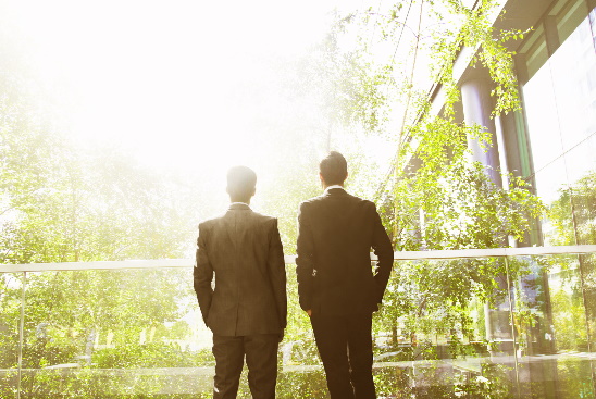 Two businessmen surrounded by trees